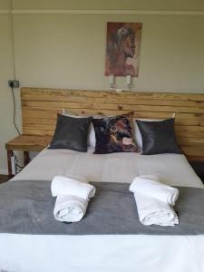 a large white bed with two towels on it at Abbastanza Self-catering in Loeriesfontein