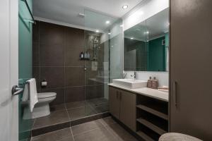 a bathroom with a sink and a toilet and a mirror at Nimolanca - 3 Bedroom Partial Ocean View in Caloundra