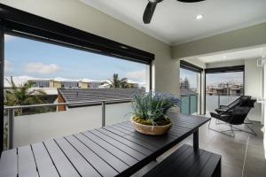 a living room with a table and a balcony at Nimolanca - 3 Bedroom Partial Ocean View in Caloundra