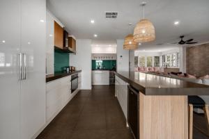 a kitchen with white cabinets and a large island at Nimolanca - 3 Bedroom Partial Ocean View in Caloundra
