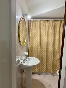 baño con lavabo y cortina de ducha en Departamento Céntrico Belgrano 1E en San Carlos de Bariloche