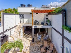 una casa con balcón con sillas y escaleras en COZY, Apartamento a solo 10 minutos Caminando a Playa Dormida, con Piscina y Parqueadero., en Santa Marta