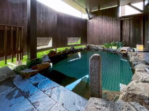 a swimming pool in a house with a stone wall at TABINO HOTEL Hida Takayama in Takayama