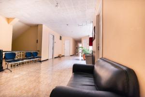 a waiting room with a leather couch and chairs at HOTEL CALLE REAL SUITE in Medellín