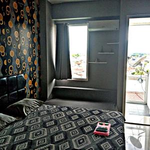 um quarto com uma cama e uma janela em Vin's Room at Vivo Apartemen em Seturan
