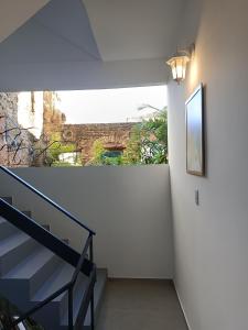 a hallway with stairs and a wall with a mirror at Casa Almeida in Salvador
