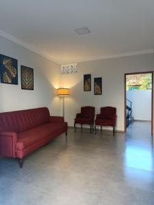 a living room with a red couch and two chairs at Casa Almeida in Salvador