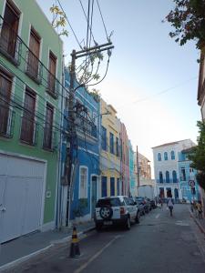une rue avec des voitures garées sur le côté d'un bâtiment dans l'établissement Casa Almeida, à Salvador