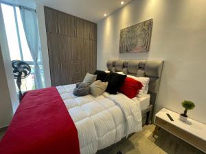 1 dormitorio con 1 cama grande y almohadas coloridas en PP Nuevo Apartamento Moderno y Central, en Ibagué