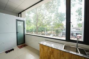 uma cozinha com um lavatório e uma grande janela em Thanh Ngọc Motel em Buon Ma Thuot