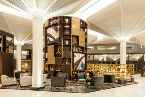 un vestíbulo de un hotel con sillas y una biblioteca en Le Méridien Dubai Hotel & Conference Centre en Dubái