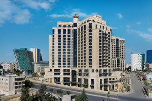 a large white building in a city with a street at The St. Regis Amman in Amman