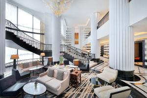 un hall avec des canapés, des tables et un escalier dans l'établissement The St. Regis Amman, à Amman 191 autres photos