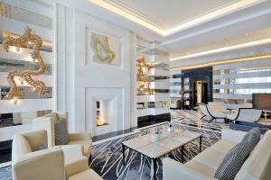 - un hall avec des chaises blanches et une table dans la chambre dans l'établissement The St. Regis Amman, à Amman
