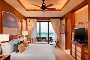 a hotel room with two beds and a television at The St. Regis Saadiyat Island Resort, Abu Dhabi in Abu Dhabi