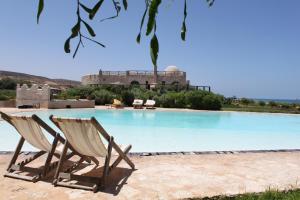 zwei Liegestühle neben einem Swimmingpool in der Unterkunft Bubble on the Beach - Dar Danse in Zaouia Akermoud