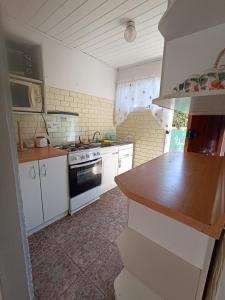 uma cozinha com armários brancos e um forno com placa de fogão em Cabaña Anita em El Quisco