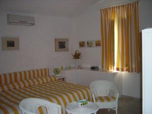 トロペアにあるVilla Paradisoのベッドルーム1室(ベッド1台、椅子、窓付)