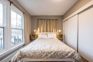 ein Schlafzimmer mit einem Bett und einem großen Fenster in der Unterkunft Cozy Chic Oasis 3 Bedroom in Halifax