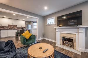 a living room with a fireplace and a kitchen at Cozy Chic Oasis 3 Bedroom in Halifax