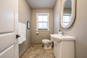 a bathroom with a toilet and a sink and a mirror at Cozy Chic Oasis 3 Bedroom in Halifax