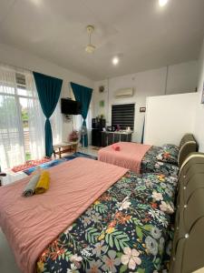 2 łóżka w pokoju z niebieskimi zasłonami w obiekcie Heaven republic Studio w mieście Kangar