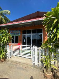 a house with a white fence in front of it at Heaven republic Studio in Kangar