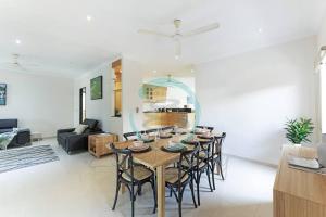 a dining room and living room with a table and chairs at Zenhouse (Bayview) 4BR Luxury Family Home Pool/BBQ in Stuart Park