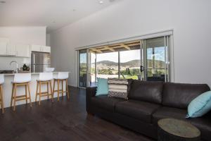 a living room with a couch and a kitchen at Stay in Mudgee in Mudgee