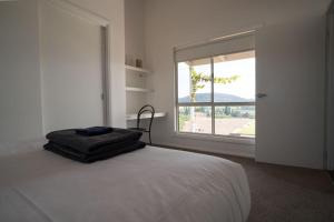 a bedroom with a bed and a large window at Stay in Mudgee in Mudgee