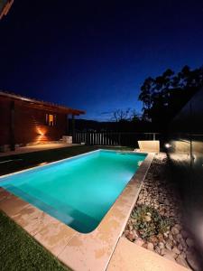 a swimming pool in a backyard at night at Perfect Mountain Lodge with Pool in Fafião