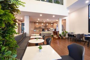 a restaurant with tables and chairs and a kitchen at Joli Hotel in Phnom Penh