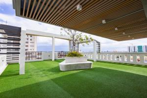 a balcony with green grass and a tree on it at Joli Hotel in Phnom Penh