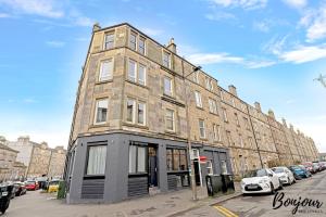 a large brick building on a street with parked cars at Mabillon Suite - Gorgeous-Haymarket, City Centre-FREE Parking by Bonjour Residences Edinburgh in Edinburgh