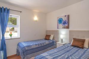 1 Schlafzimmer mit 2 Betten und einem Fenster in der Unterkunft Casa Caravela, Praia da Luz in Luz