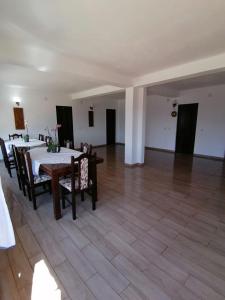 comedor con mesa y sillas en un suelo de madera en Conacul Elenei en Poiana Mărului