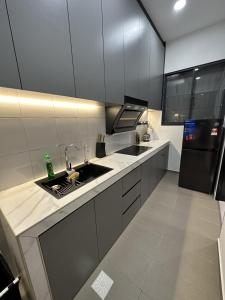 a kitchen with a sink and a black refrigerator at Sandakan SeaView-Suite Top Floor in Sandakan