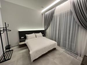 a bedroom with a bed and a large window at Sandakan SeaView-Suite Top Floor in Sandakan