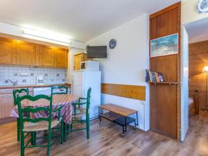 a kitchen with a table and chairs and a refrigerator at Appartement La Plagne, 2 pièces, 4 personnes - FR-1-351-80 in La Plagne