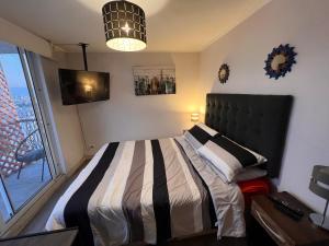 a bedroom with a bed and a large window at Depto Matucana in Santiago