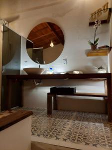 Casa de Praia Alameda Azul في غواراباري: حمام مع حوض ومرآة