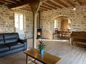 a living room with a couch and a piano at Maison de ferme rénovée 18ème avec jardin, cheminée, Wi-Fi et parking - FR-1-489-433 in Ygrande