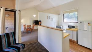 a kitchen and dining room with a counter and a refrigerator at Executive Hideaway in Benalla