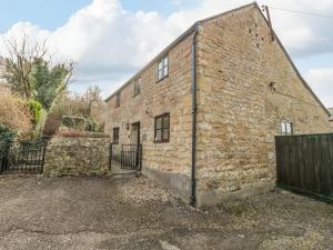 an old brick building with a gate and a fence at The Old Dairy in Bridport
