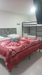 Un dormitorio con una cama con una manta roja. en Apartahotel El paraiso en Cali