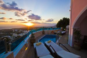 a balcony with a pool and a sunset at Nectarios Villa - Studios & Suites Adults Only in Fira