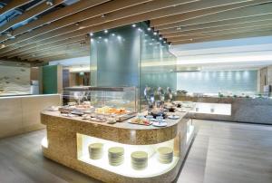 a buffet line in a restaurant with food on display at Nina Hotel Island South in Hong Kong