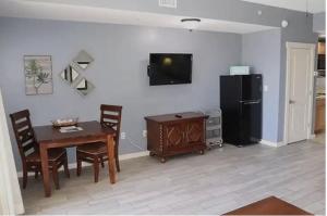 a dining room with a table and a refrigerator at Origin at Seahaven in Panama City Beach