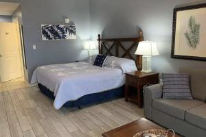 a bedroom with a bed and a couch at Origin at Seahaven in Panama City Beach