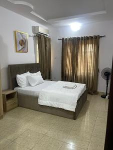 um quarto com uma cama grande e lençóis brancos em Beautiful 2Br Apt in Ogba, Ikeja, Lagos em Lagos